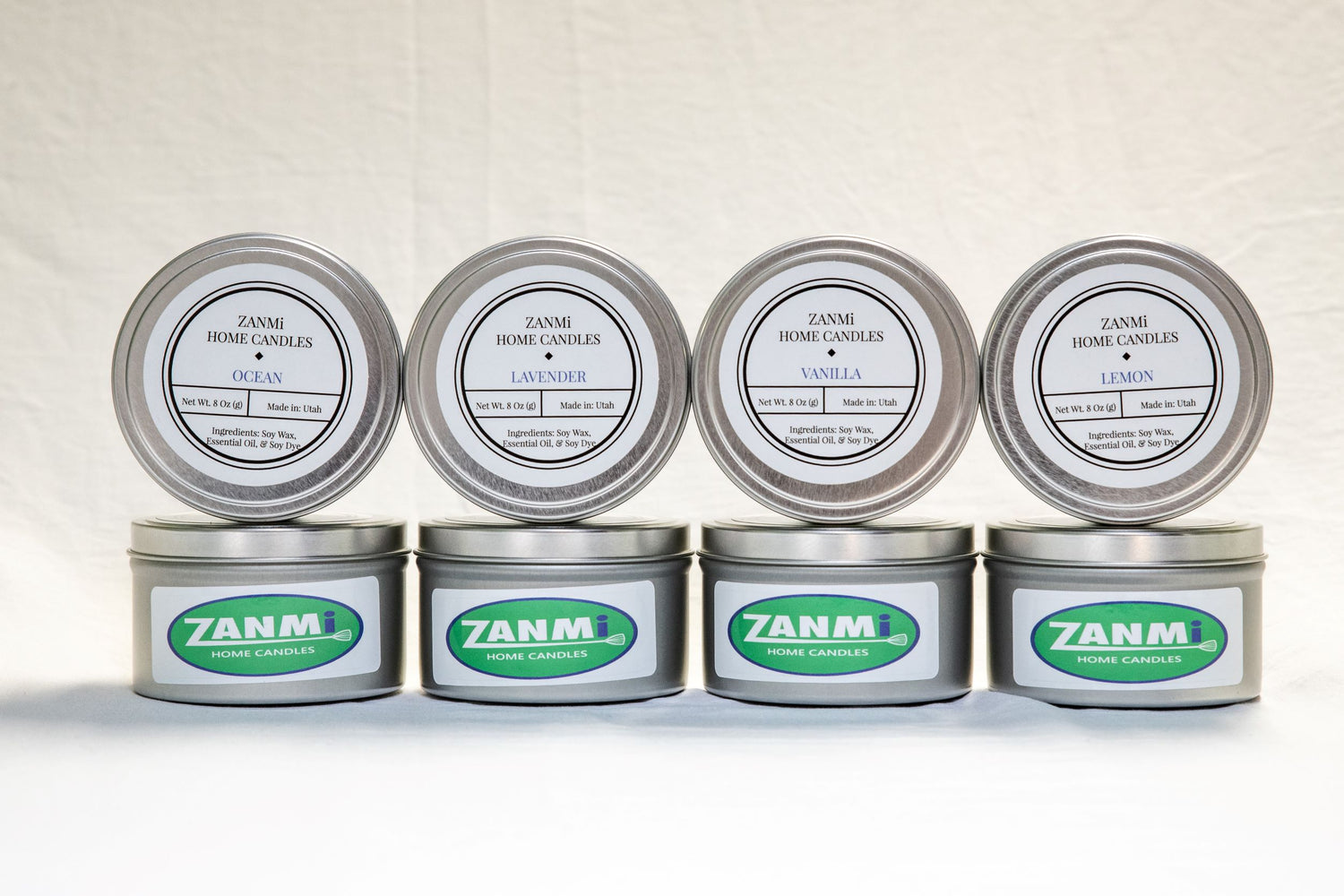 A row of four vegan soy wax candles lined up on a white background.